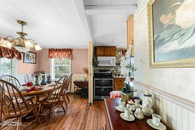 kitchen with white appliances, sink, dark hardwood / wood-style flooring, tile walls, and decorative light fixtures