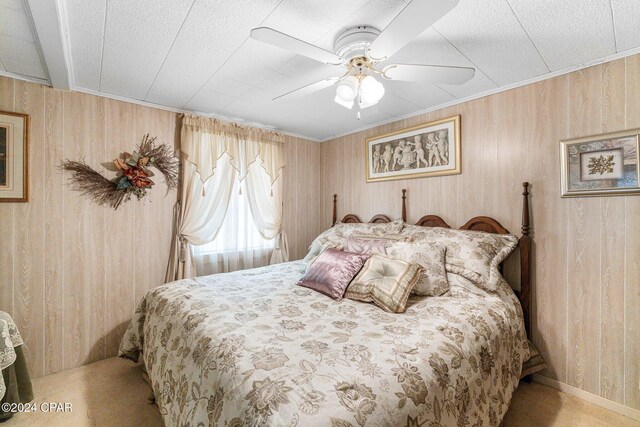 bedroom featuring light carpet and wooden walls