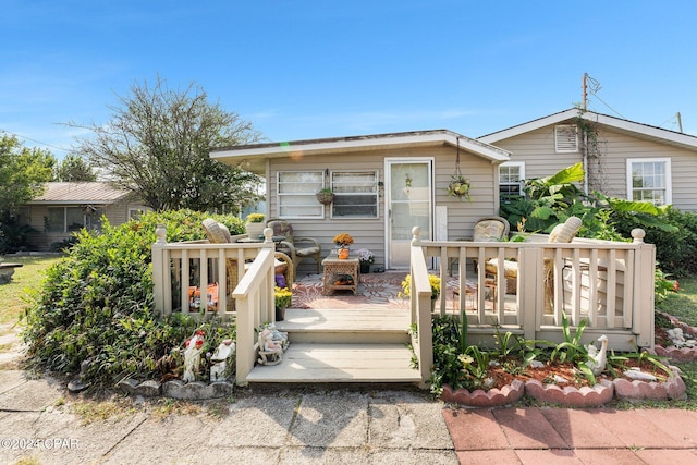 rear view of property featuring a wooden deck