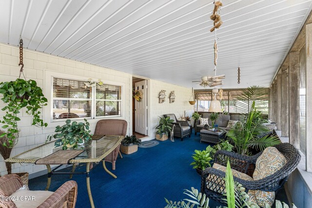 sunroom / solarium featuring ceiling fan