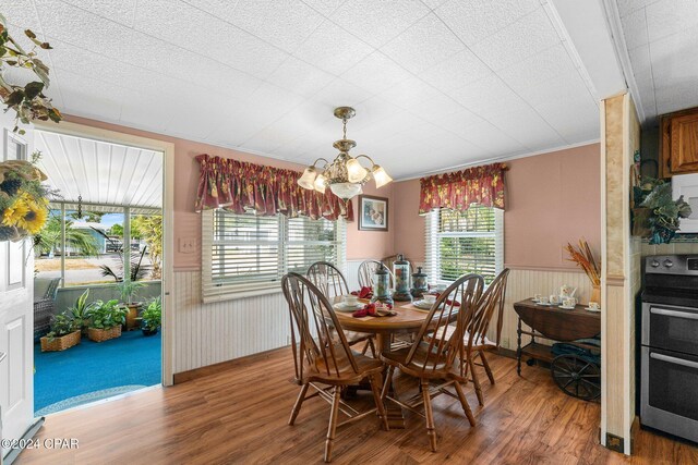 dining space with hardwood / wood-style floors and an inviting chandelier