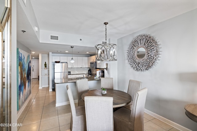 dining space with light tile patterned floors and a notable chandelier