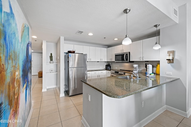 kitchen featuring white cabinets, kitchen peninsula, stainless steel appliances, and hanging light fixtures