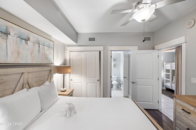 bedroom featuring ensuite bathroom, dark hardwood / wood-style flooring, ceiling fan, and a closet