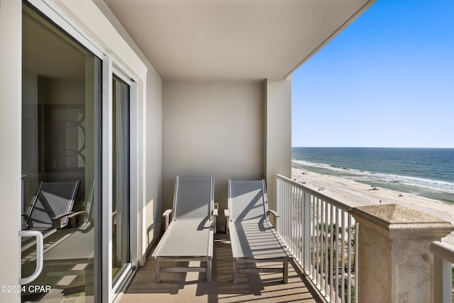 balcony featuring a beach view and a water view