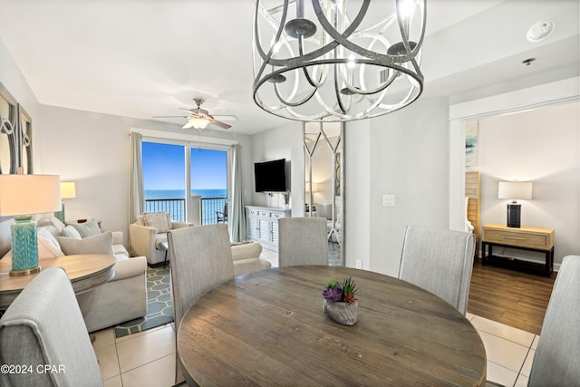 dining room with light wood-type flooring and ceiling fan with notable chandelier