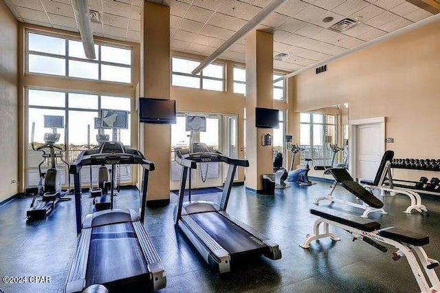 exercise room with a drop ceiling and plenty of natural light