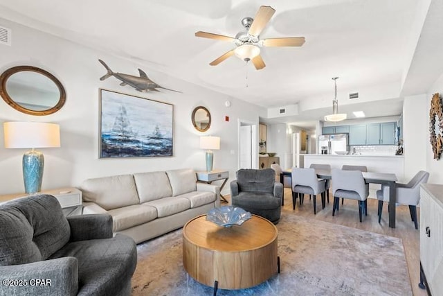 living room with ceiling fan and light hardwood / wood-style flooring