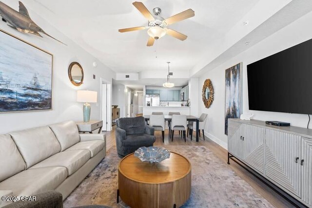 living room featuring ceiling fan, a textured ceiling, and a water view