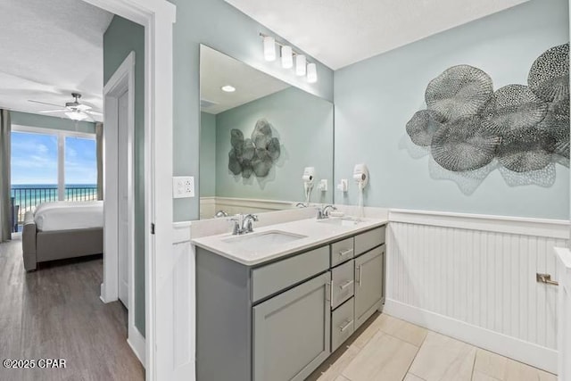 bathroom featuring vanity, hardwood / wood-style flooring, ceiling fan, and a water view