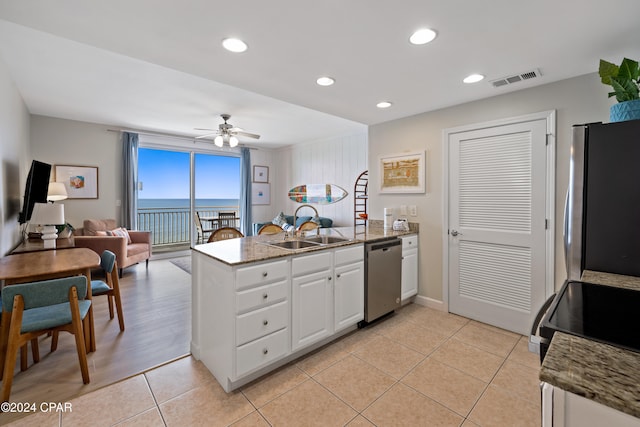 kitchen featuring white cabinetry, kitchen peninsula, stainless steel appliances, and a water view