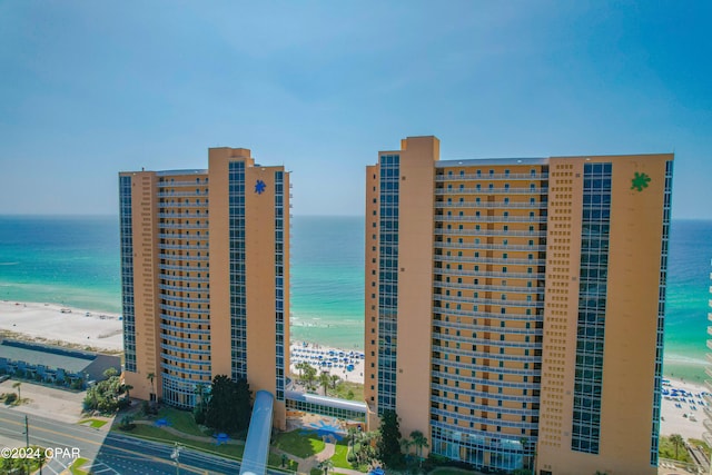 view of building exterior featuring a beach view and a water view