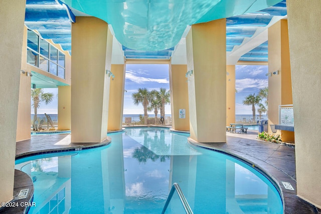 view of pool featuring a patio and a water view