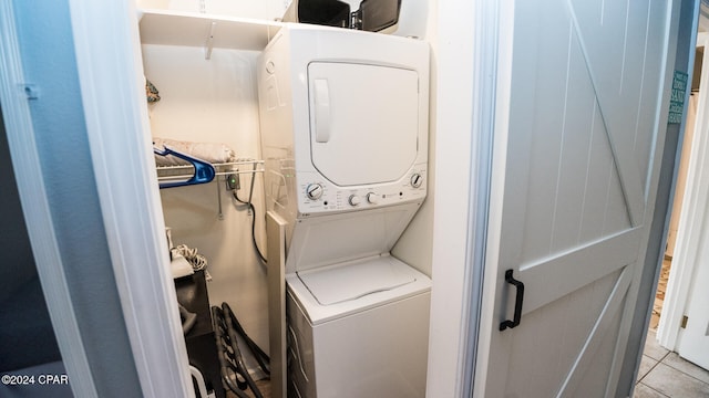 laundry area featuring stacked washing maching and dryer and light tile patterned floors