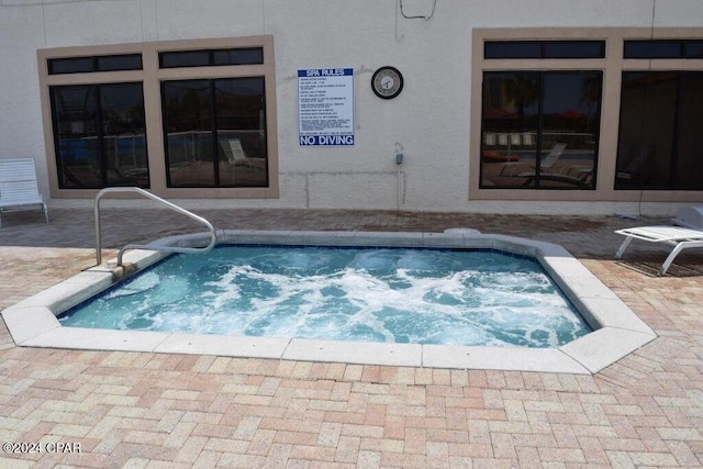 view of swimming pool with a hot tub and a patio area