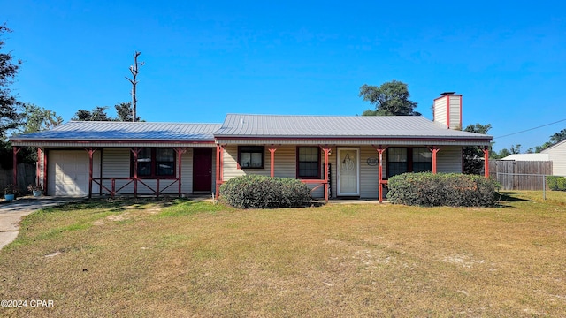 ranch-style home with covered porch, a front yard, and a garage