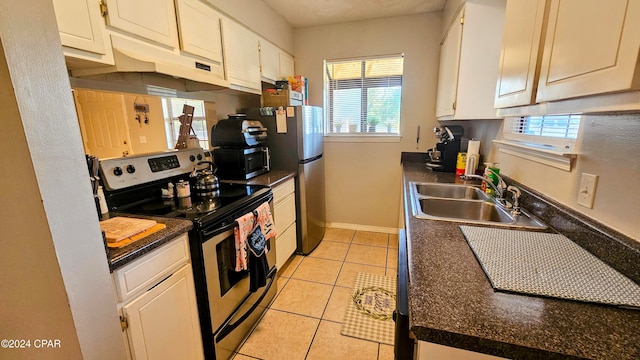 kitchen with white cabinets, appliances with stainless steel finishes, a textured ceiling, light tile patterned flooring, and sink