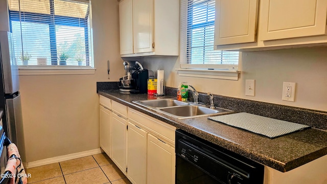 kitchen featuring black dishwasher, sink, white cabinetry, and light tile patterned floors