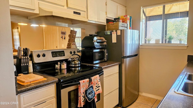 kitchen with appliances with stainless steel finishes, white cabinets, and a wealth of natural light