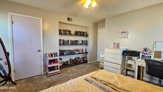 bedroom featuring a textured ceiling, ceiling fan, and dark colored carpet