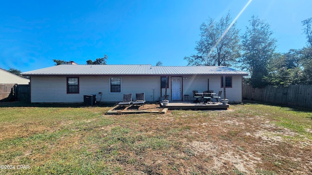 back of property featuring central air condition unit, a deck, and a lawn