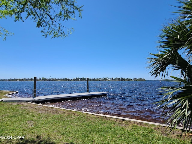 dock area featuring a water view and a lawn