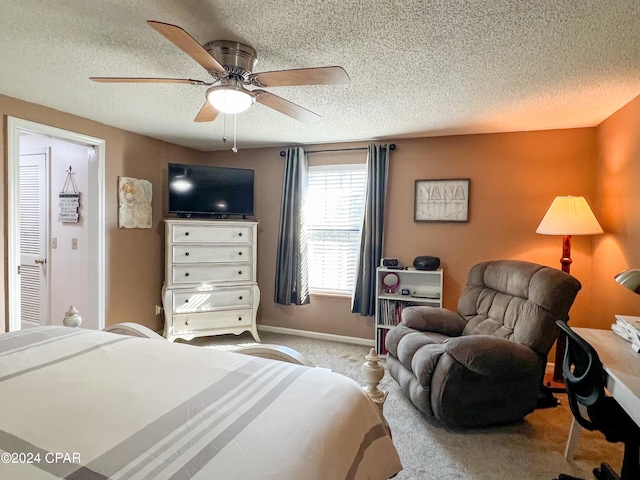 carpeted bedroom with ceiling fan and a textured ceiling