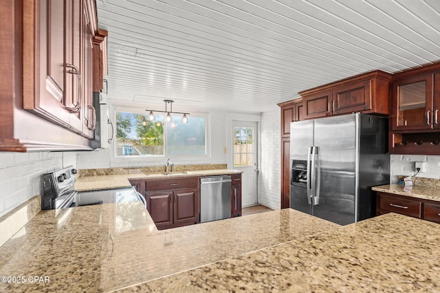 kitchen with a healthy amount of sunlight, stainless steel appliances, sink, and hanging light fixtures