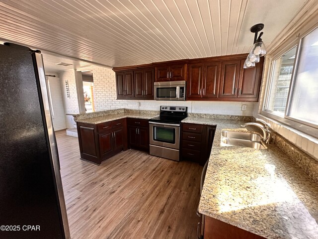 kitchen featuring pendant lighting, stainless steel refrigerator with ice dispenser, brick wall, wooden ceiling, and light wood-type flooring