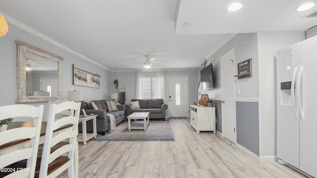 living room with ornamental molding, ceiling fan, and light hardwood / wood-style flooring