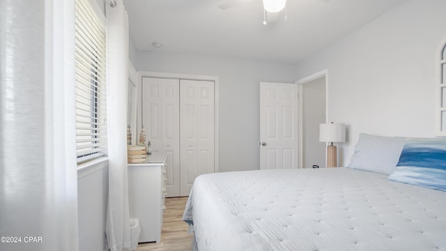 bedroom featuring ceiling fan, light hardwood / wood-style floors, and a closet