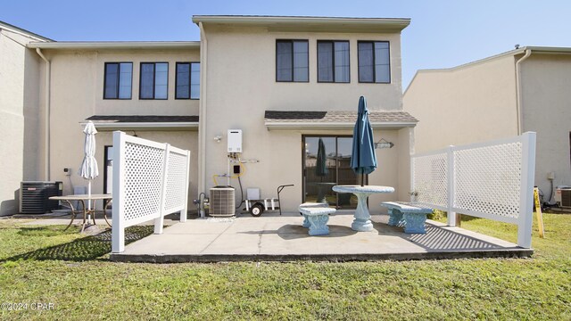 rear view of property with cooling unit and a yard