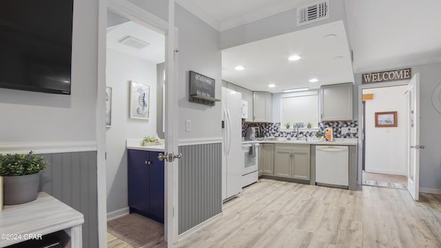 kitchen featuring white appliances, ornamental molding, sink, and light hardwood / wood-style flooring