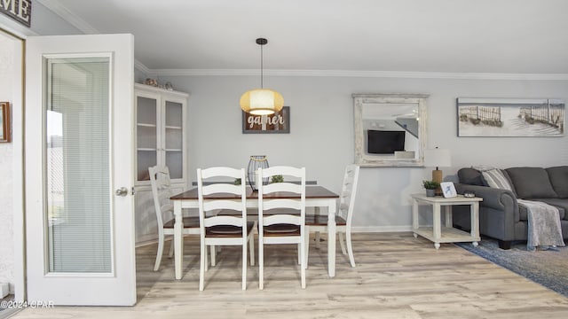 dining space featuring crown molding and light hardwood / wood-style flooring