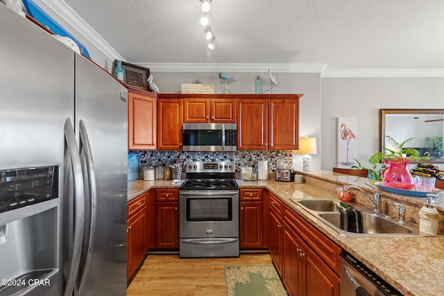 kitchen featuring appliances with stainless steel finishes, light hardwood / wood-style flooring, ornamental molding, and sink