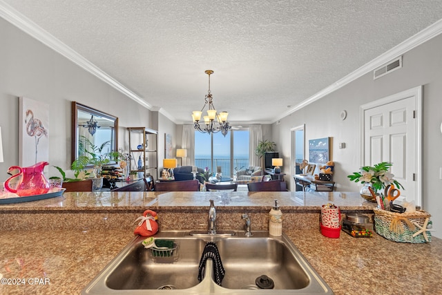 kitchen featuring crown molding, a textured ceiling, and a chandelier