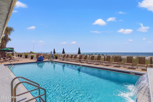 view of pool with a patio area, pool water feature, and a water view