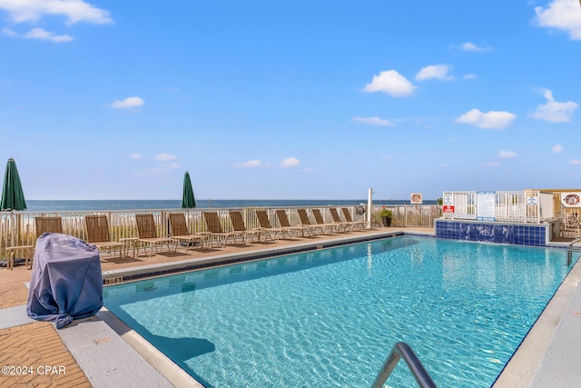 view of swimming pool featuring pool water feature and a water view