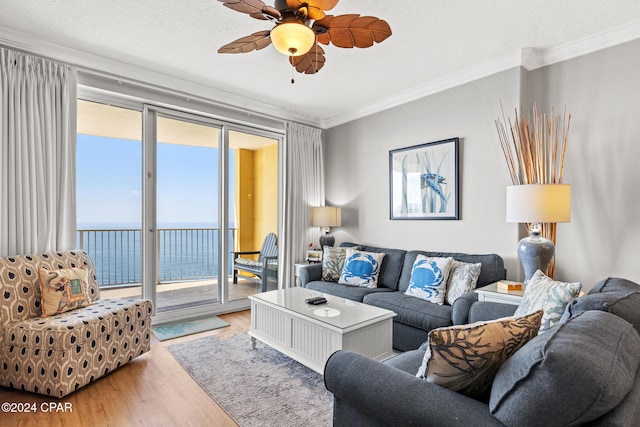 living room featuring hardwood / wood-style floors, crown molding, a textured ceiling, a water view, and ceiling fan