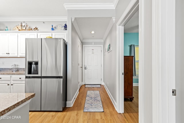 kitchen with white cabinetry, light hardwood / wood-style floors, ornamental molding, and stainless steel fridge with ice dispenser