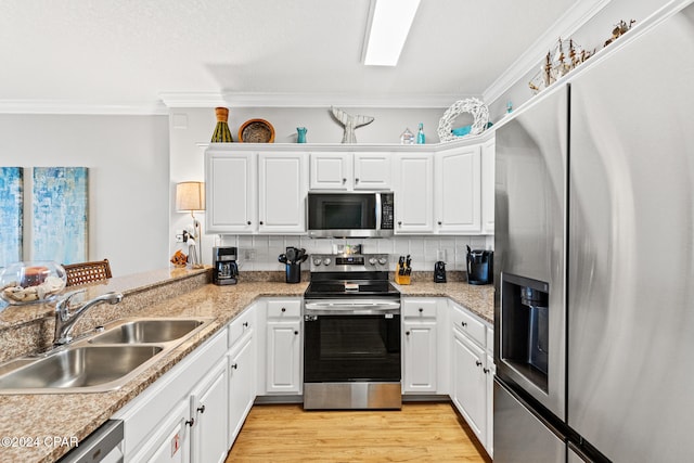 kitchen with white cabinetry, crown molding, appliances with stainless steel finishes, and sink