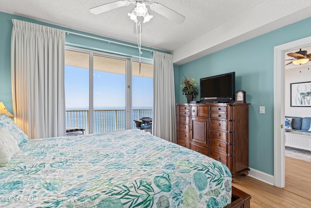 17545 Front Beach Rd Unit 2308, Panama City Beach, FL 32413 - bedroom with access to exterior, wood finished floors, a textured ceiling, baseboards, and a ceiling fan