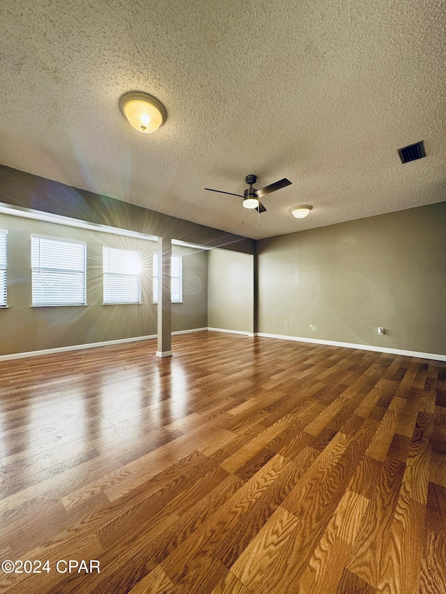 unfurnished room with hardwood / wood-style floors, ceiling fan, and a textured ceiling