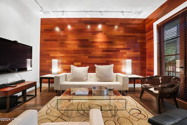 dining room with track lighting and wood walls