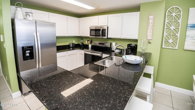 15817 Front Beach Rd Unit 1-906, Panama City Beach, FL 32413 - kitchen featuring appliances with stainless steel finishes, light tile patterned floors, a sink, and white cabinets