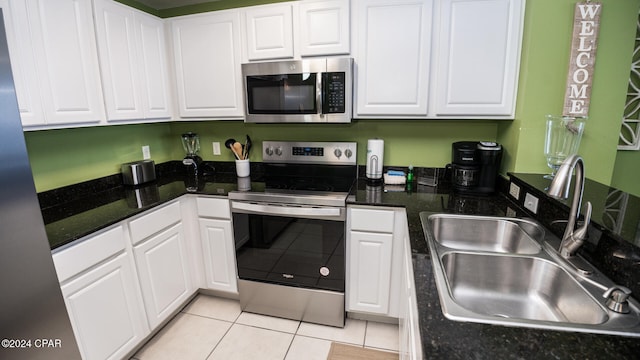 kitchen featuring stainless steel appliances, white cabinetry, sink, and light tile patterned floors