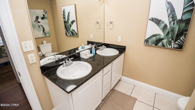 bathroom with toilet, vanity, and tile patterned floors