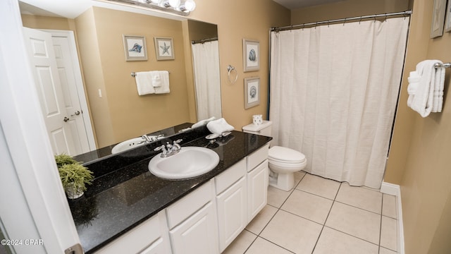 bathroom featuring toilet, vanity, and tile patterned flooring