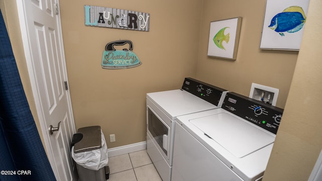 laundry area with light tile patterned flooring and washer and dryer