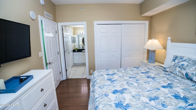 bedroom with a closet, wood-type flooring, and ensuite bathroom